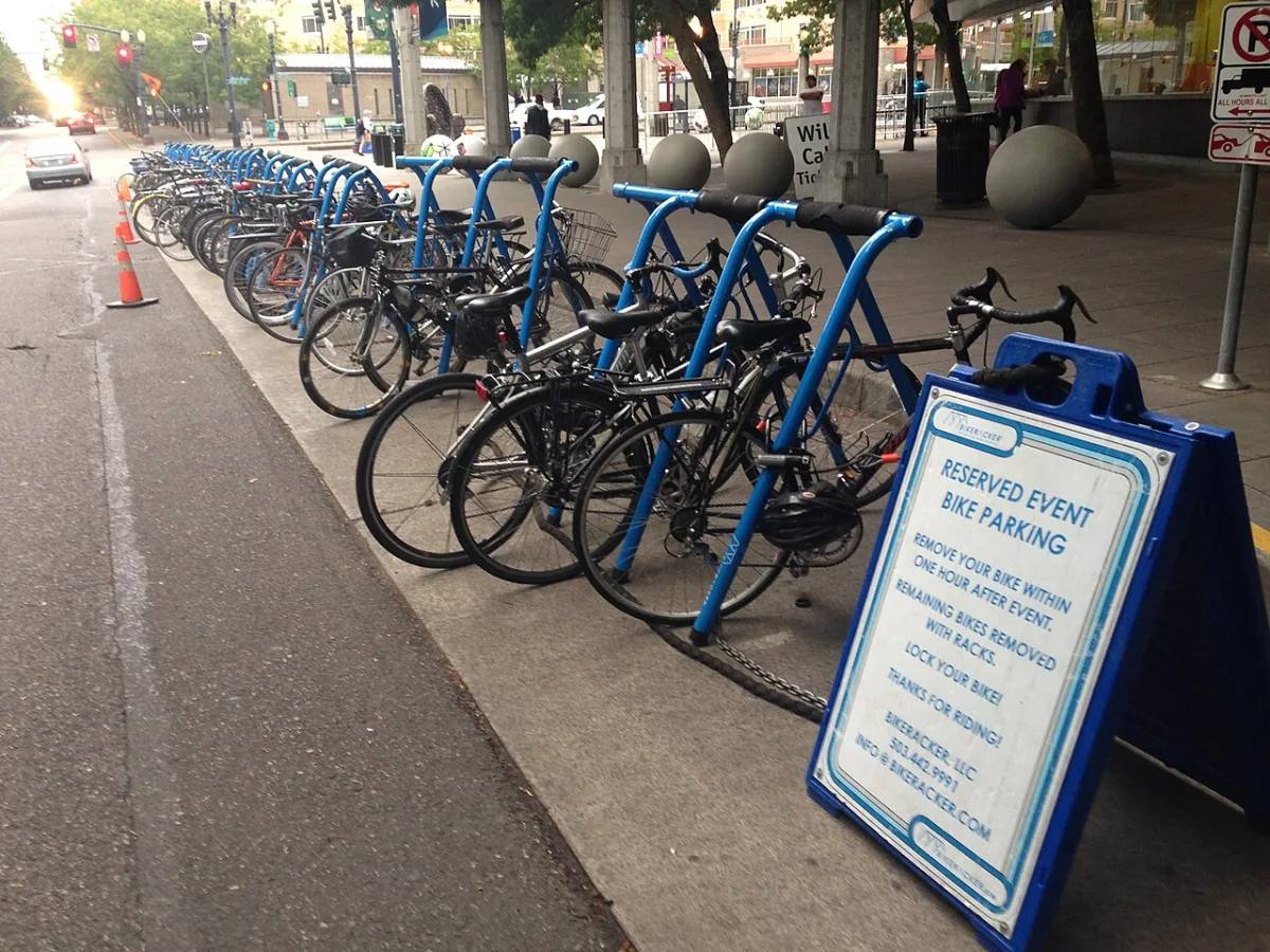 Lange rij blauwe fietsbeugels met fietsen bij een evenement